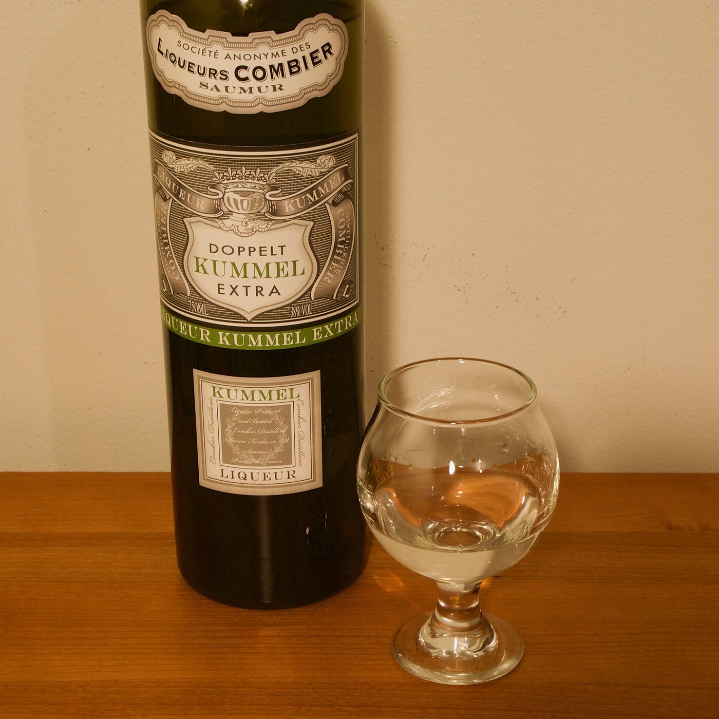 Copa de cata con licor Kümmel, transparente, sobre una mesa.