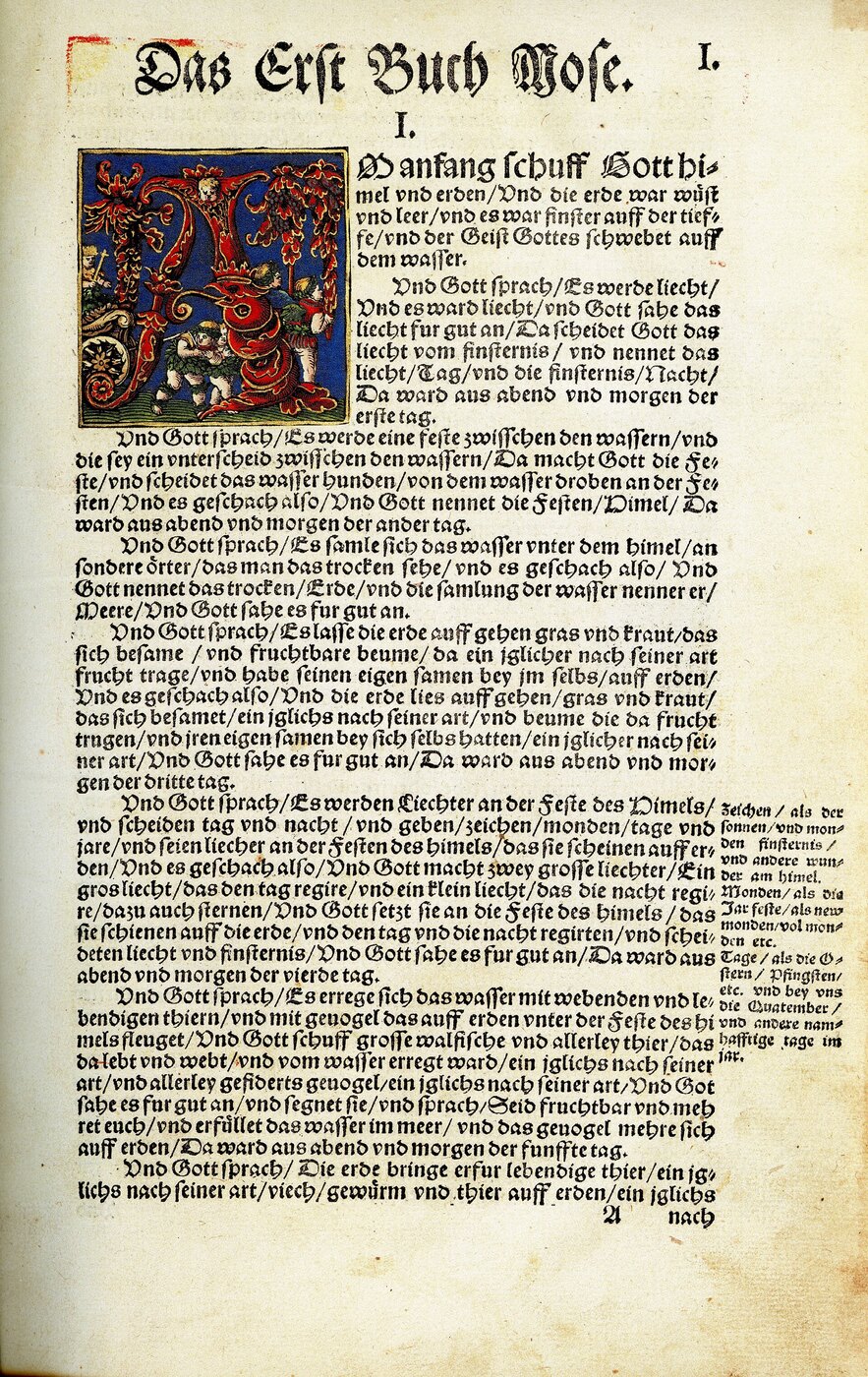Página del Génesis en la Biblia de Lutero de 1534, en letra gótica, con una inicial ilustrada a color y notas al margen.